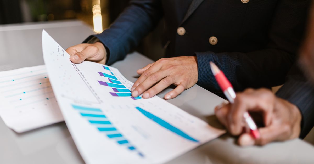 Executives reviewing reports with charts in a business meeting